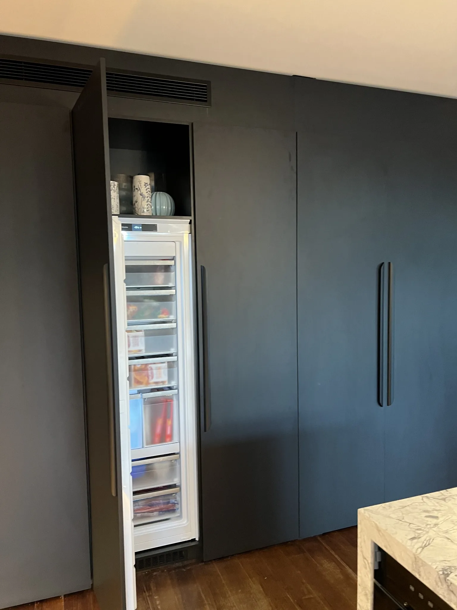 Matte black joinery with integrated freezer