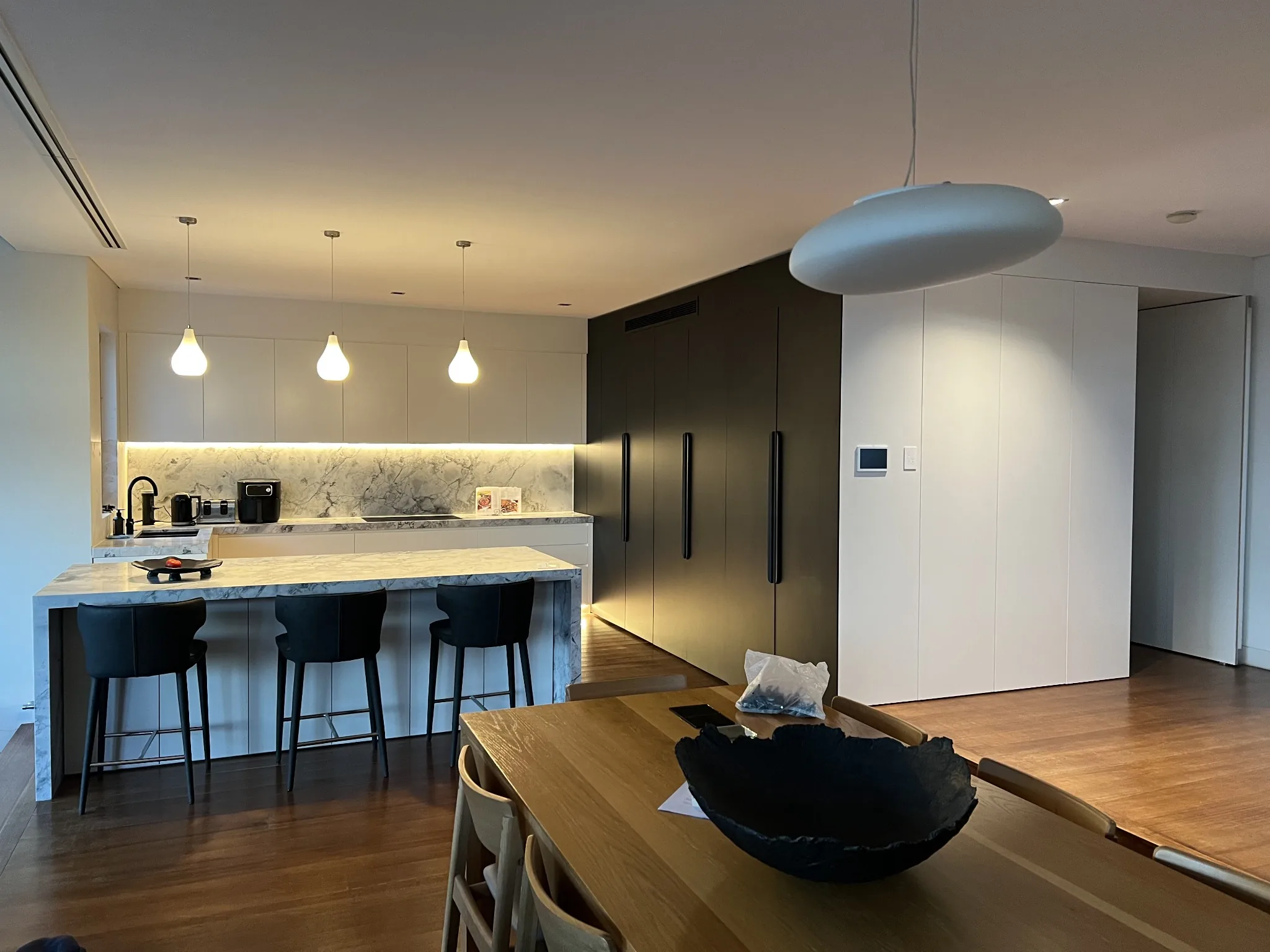 Dark and white kitchen viewed from dining area
