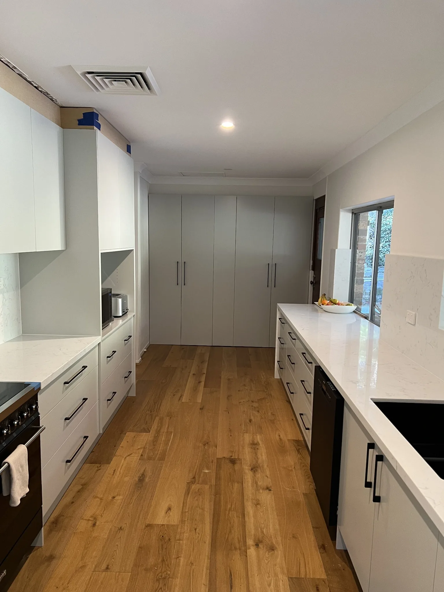 Long white galley kitchen with pantry storage